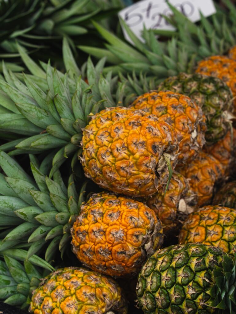 Fresh pineapples with green leaves on display